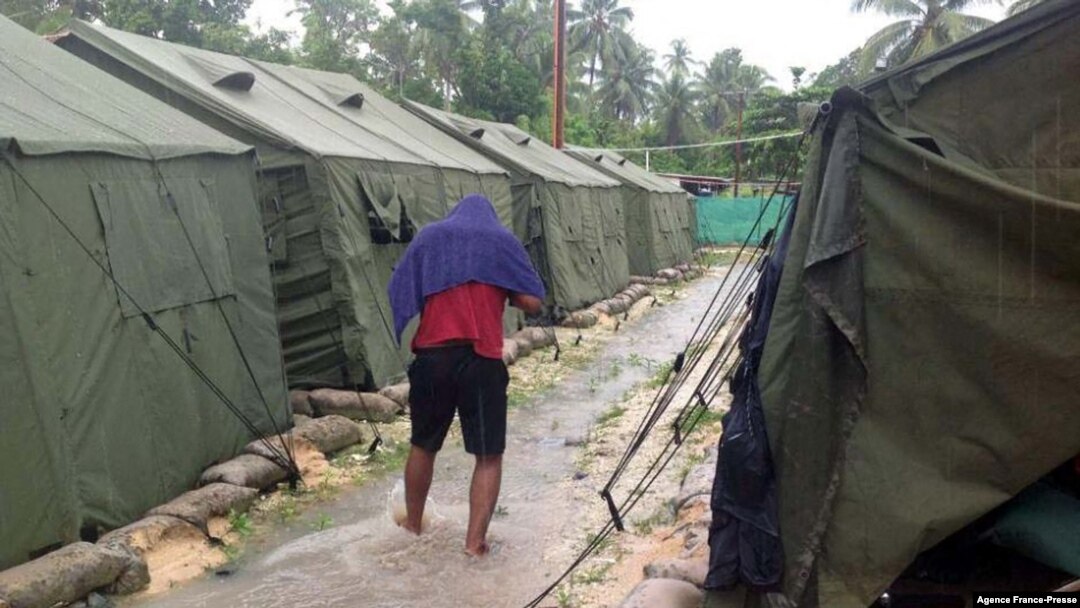 FILE - An undated photo from the Refugee Action Coalition on Feb. 18, 2014, shows a man walking between tents at Australia's regional processing center on Manus Island in Papua New Guinea. 