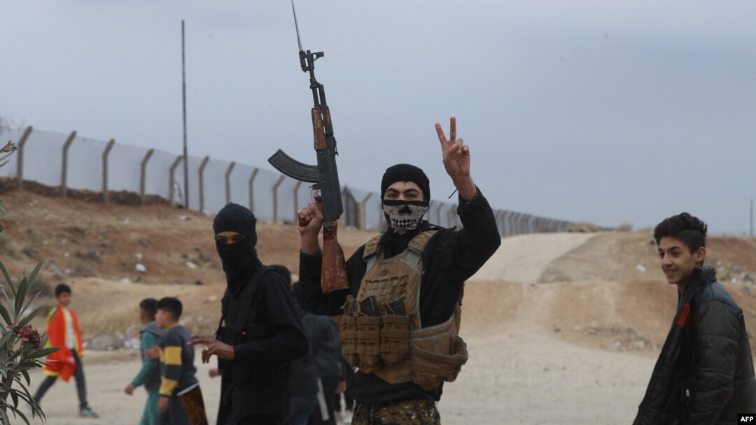 A Syrian Kurdish fighter flashes the V-sign for victory as local gunmen control the area around Qamishli's airport in northeastern Syria on Dec. 8, 2024