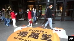People wear face masks to protect against the spread of the coronavirus as they walk through a shopping district in Taipei, Taiwan, Oct. 29, 2020.