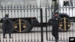 FILE - Police officers guard a court building in Rostov-on-Don, Russia, Sept. 15, 2015. On Monday, a Russian military court in western city of Penza sentenced seven members of a left-wing group to prison terms of up to 18 years on terrorism charges. 