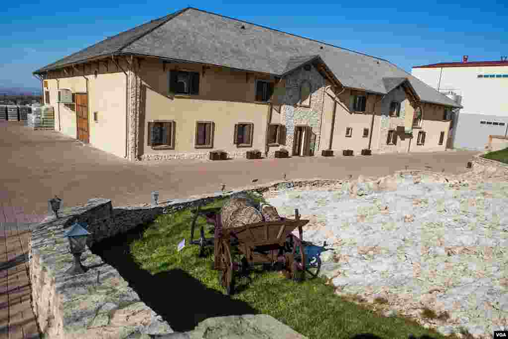 An old grape harvesting cart stands in front of Chateau Vartely's new bottling building. A sign the new trend in Moldovan agriculture, this winery uses equipment imported from France, Germany and Italy. (Vera Undritz for VOA)