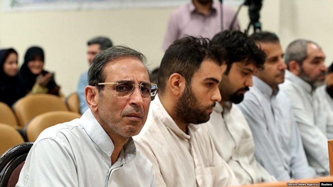 FILE - Vahid Mazloumin (L) is seen appearing in court for the first time on charges of manipulating the currency market. He was later sentenced to death, in Tehran, Sept. 8, 2018