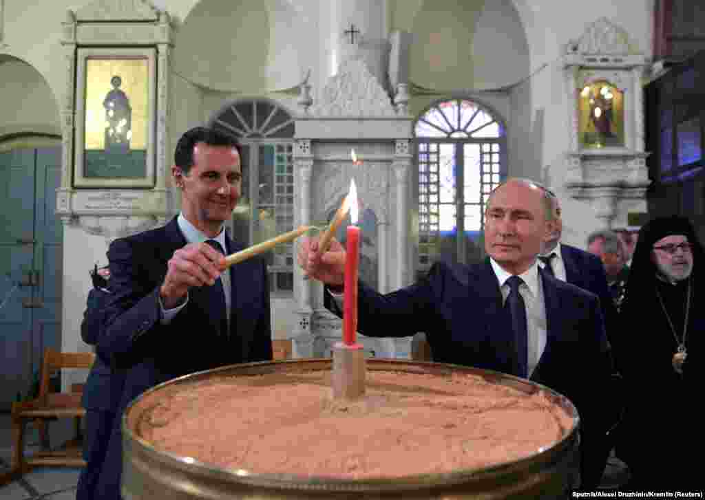 Russian President Vladimir Putin and his Syrian counterpart Bashar al-Assad visit an Orthodox Christian cathedral in Damascus, Syria, Jan. 7, 2020.