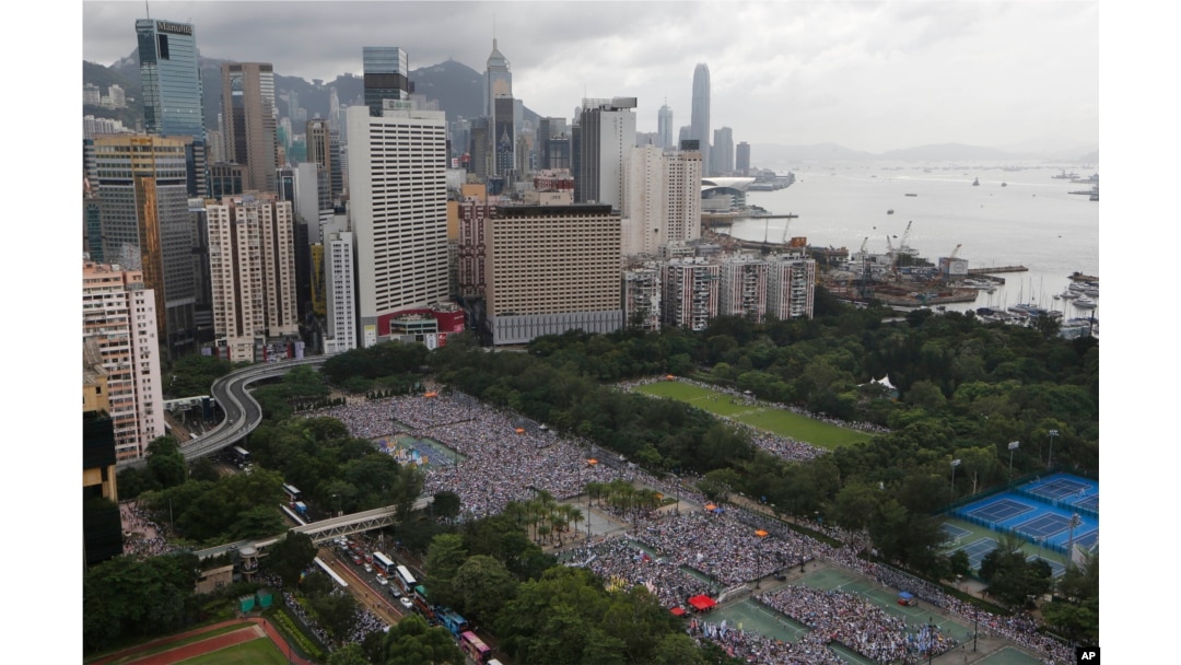 Tens of thousands of residents gather to march in downtown streets during an annual pro-democracy protest in Hong Kong Tuesday, July 1, 2014. Hong Kong residents began marching through the streets of the former British colony to push for greater democracy