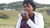 South African woman holds a cloth in front of her mouth as she coughs up blood. (VOA/D.Taylor)