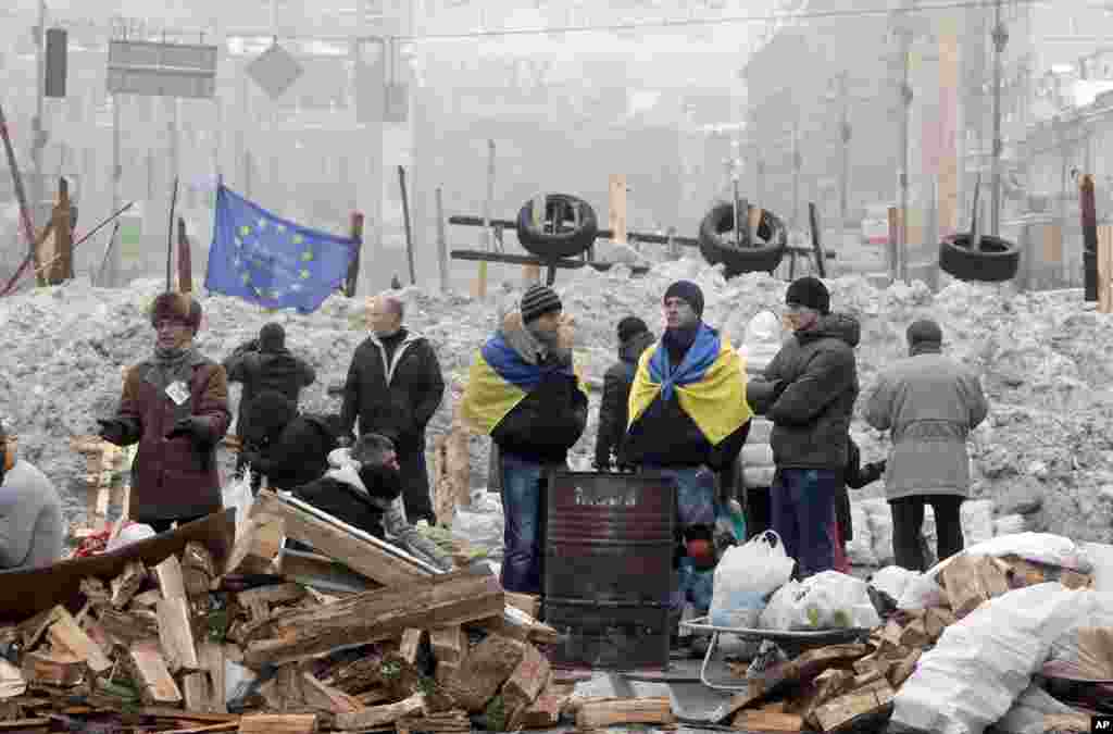 Pro-European Union activists warm themselves near a bonfire and guard barricades on the main street Khreschatyk in Kyiv, Dec. 12, 2013.