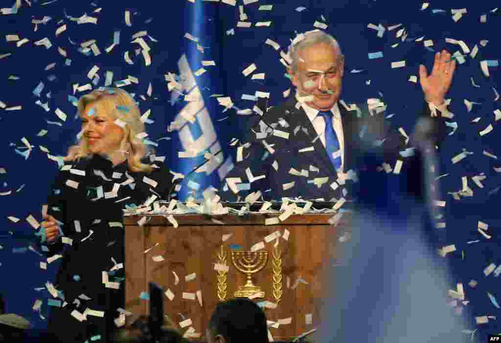 Israeli Prime Minister Benjamin Netanyahu and his wife, Sara, address supporters as confetti falls upon them at the Likud party campaign headquarters in the coastal city of Tel Aviv, after polls officially closed.