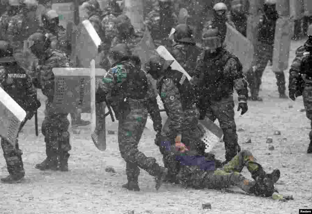 Riot police hold a man during clashes with pro-European protesters in Kyiv, Jan. 22, 2014.