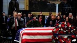 El exsenador Bob Dole, saluda el ataúd cubierto con la bandera de EE.UU. que contiene el cuerpo del expresidente George H.W. Bush y que yace en capilla ardiente en el Capitolio, en Washington. Diciembre 4 de 2018.
