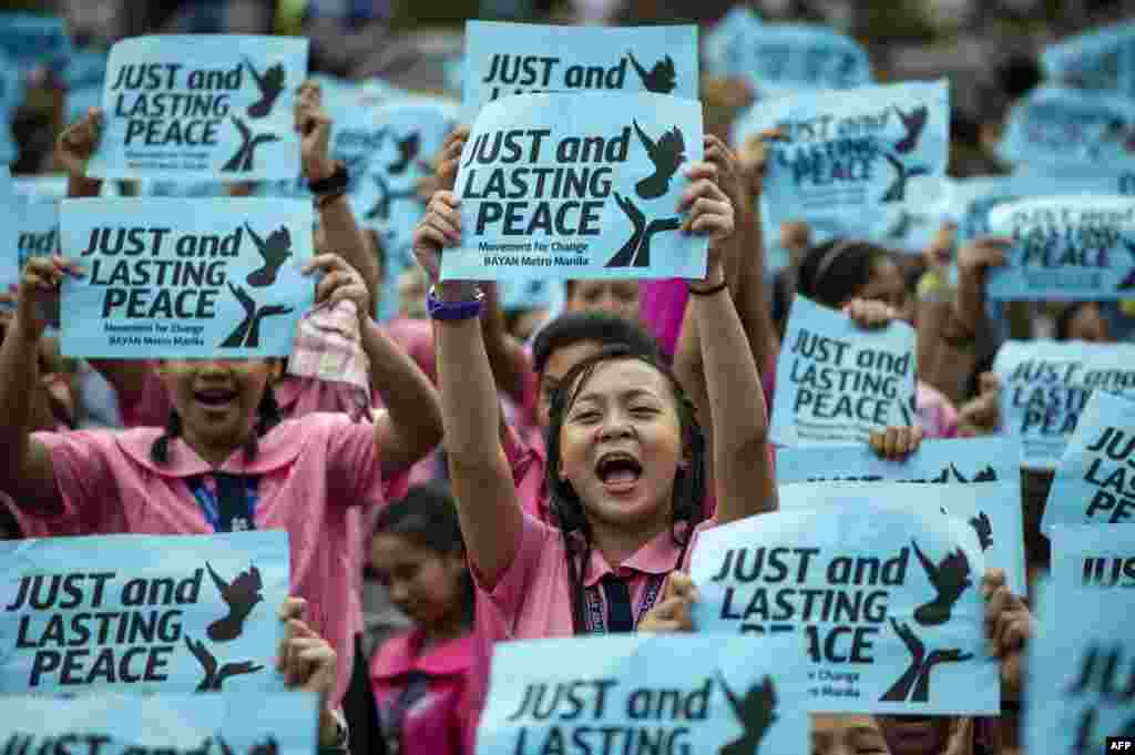 High school students hold banners calling for just and lasting peace as Philippine President Rodrigo Duterte marks his first 100 days in office in Manila. The group urge Duterte to end crime, drugs, and poverty through peace-building.