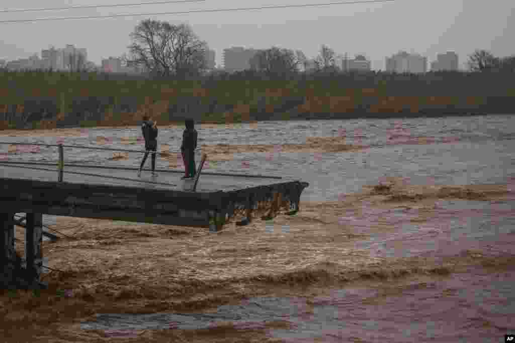 Two people take snapshots atop of a collapsed bridge in Malgrat, near Barcelona, Spain.