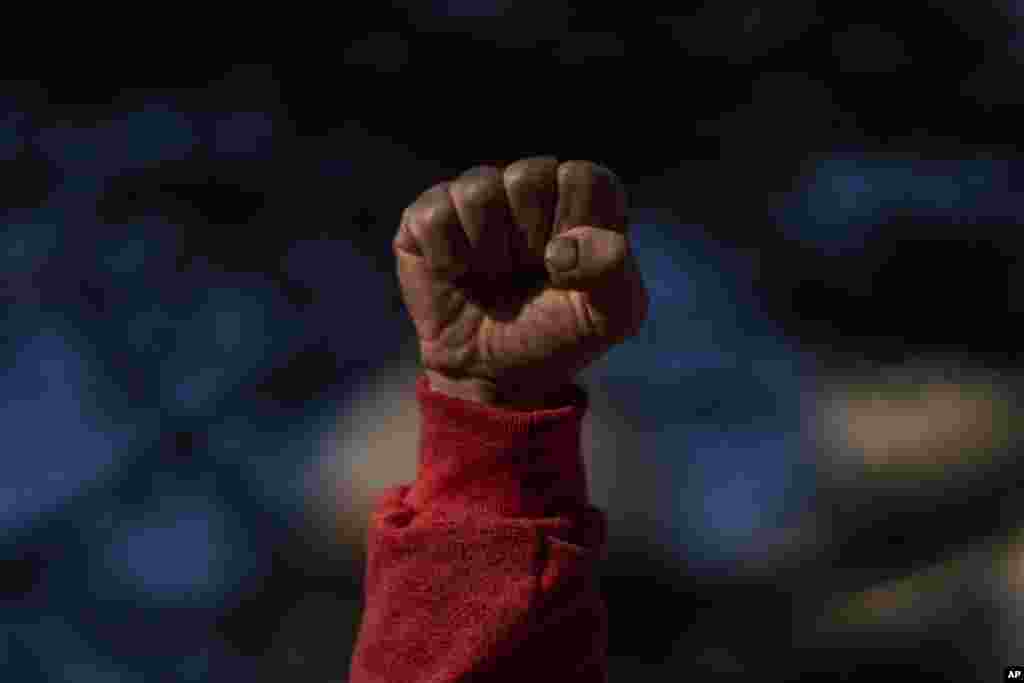 A protester clenches his fist as he sings the worker's hymn "The Internationale" during a half-day strike to protest government proposed reforms titled La Ley de Urgente, or The Urgent Law, in Montevideo, Uruguay.