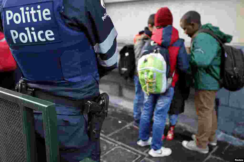 A Belgian police officer stands guard outside a school in central Brussels, Nov. 25, 2015.