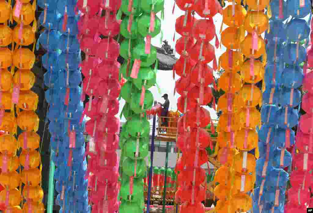 Seorang pekerja menurunkan lentera-lentera usai perayaan kelahiran Buddha di kuil Chogye, Seoul, Korea Selatan. 