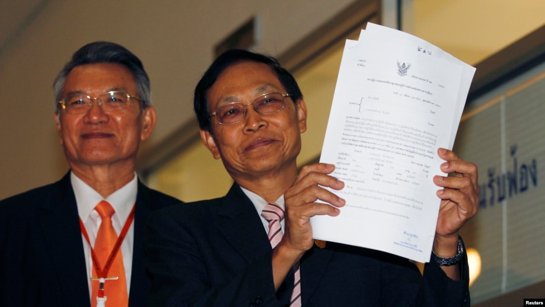 Thailand's Attorney Director General, Department of Special Litigation Chutichai Sakhakorn (R) holds filed charge papers as Director General, Department of Investigation, Surasak Threerattrakul looks on at the Supreme Court in Bangkok, February 19, 2015.