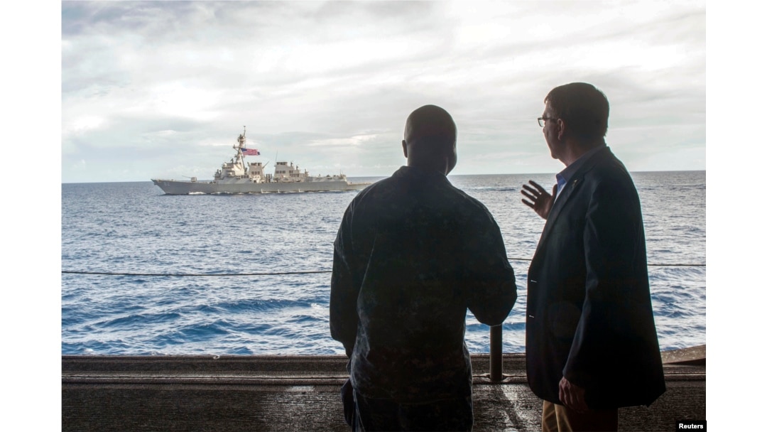 FILE - U.S. Secretary of Defense Ash Carter, right, speaks with U.S. Navy Cmdr. Robert Francis Jr., as Carter and Malaysian Defense Minister Hishammuddin Hussein (not pictured) visited the USS Theodore Roosevelt aircraft carrier in the South China Sea.