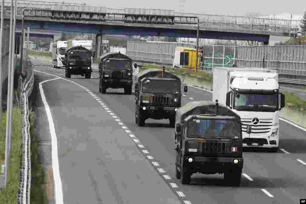 Military trucks move coffins of the deceased who died from the COVID-19 from a cemetory in Bergamo, Italy, to another as the local cremetory exceeded its maximum capacity.