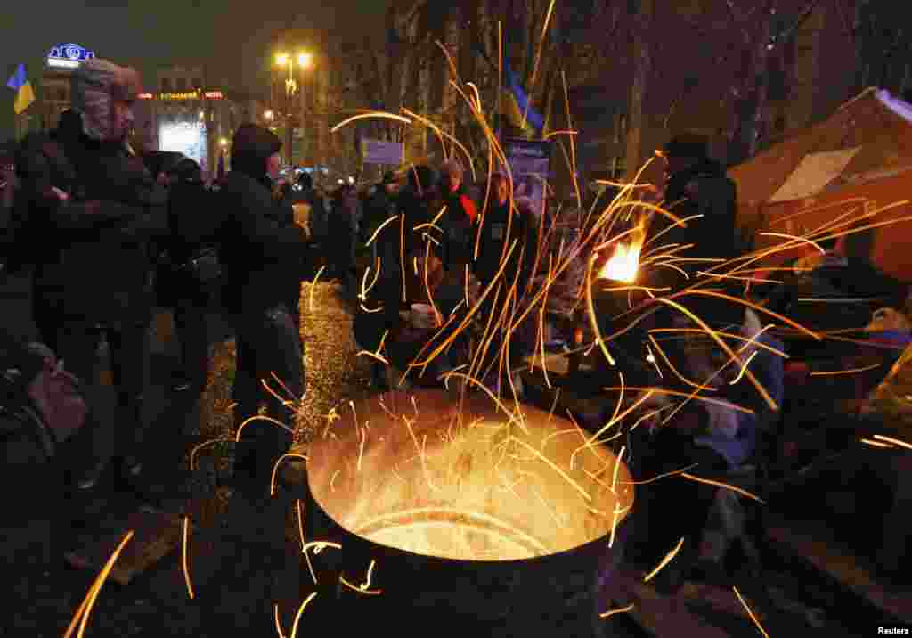 Pro-European integration protesters warm themselves by a fire in Independence Square in Kyiv, Dec. 12, 2013.
