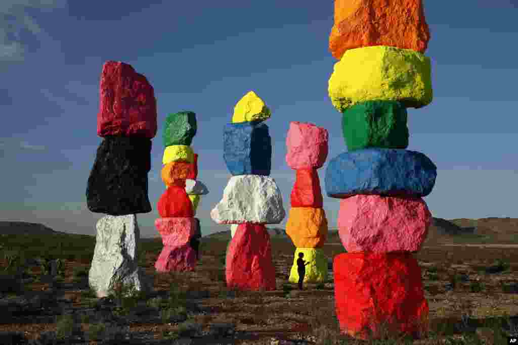 Orang-orang menyimak karya seni yang berjudul Tujuh Gunung Ajaib hasil karya artis Ugo Rondinone dekat Jean, Nevada, AS.