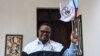 FILE - Tundu Lissu, the presidential candidate of Tanzania's main opposition Chadema party, poses with his party's flag as he speaks to the media at his home in Dar es Salaam, Tanzania, Sept. 9, 2020. 