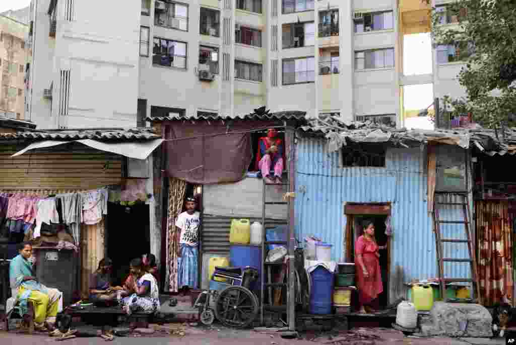 Impoverished Indians rest by their shanties at Dharavi, one of Asia's largest slums, during lockdown to prevent the spread of the coronavirus in Mumbai, India.