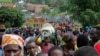 FILE - Refugees from the Democratic Republic of Congo carry their belongings as they walk near the United Nations High Commissioner for Refugees offices in Kiziba refugee camp in Karongi District, Rwanda, Feb. 21, 2018.