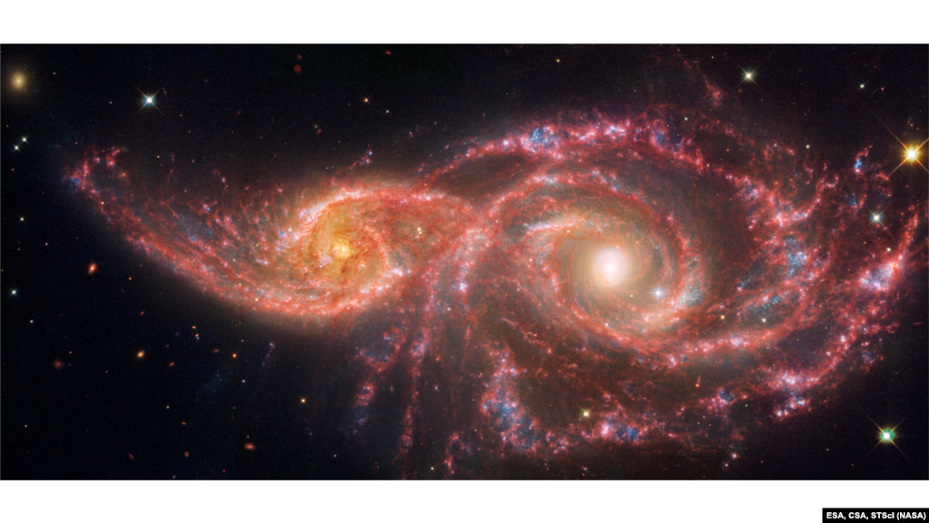 This image released by NASA’s James Webb Space Telescope, and NASA’s Hubble Space Telescope shows IC 2163, the small spiral galaxy on the left passing behind NGC 2207, the larger spiral galaxy at right. The galaxies grazed one another millions of years ago. Both galaxies have high star formation rates. Each year, the galaxies produce the equivalent of two dozen new stars that are the size of the Sun.