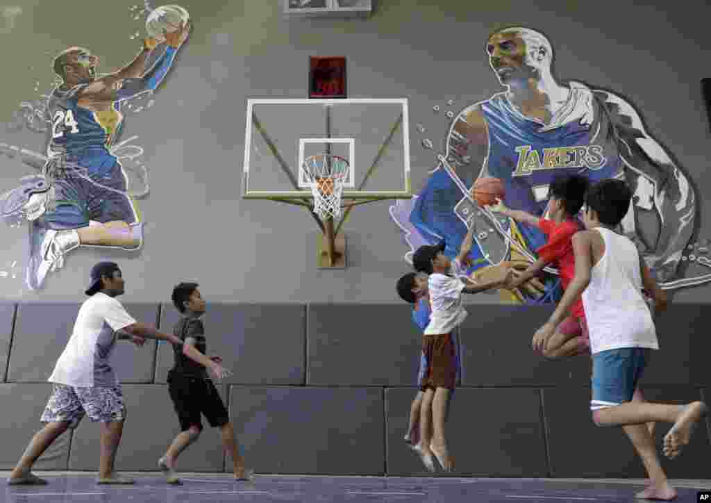 Boys plays at the "House of Kobe" basketball court in Valenzuela, north of Manila, Philippines. Fans left flowers and messages on the walls at the newly inaugurated court after learning of Bryant's death. Bryant died in a helicopter crash.