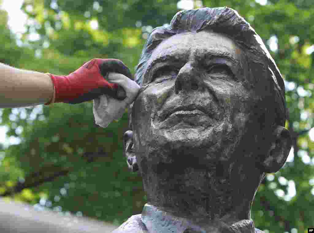 Seorang pekerja membersihkan patung mantan Presiden AS Ronald Reagan di Warsawa, Polandia.
