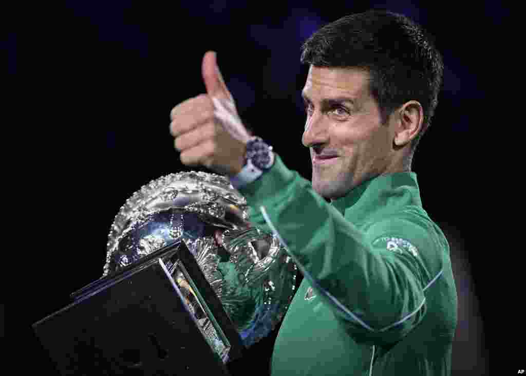 Serbia's Novak Djokovic gestures as he holds the Norman Brookes Challenge Cup after defeating Austria's Dominic Thiem in the final of the Australian Open tennis championship in Melbourne, Australia.