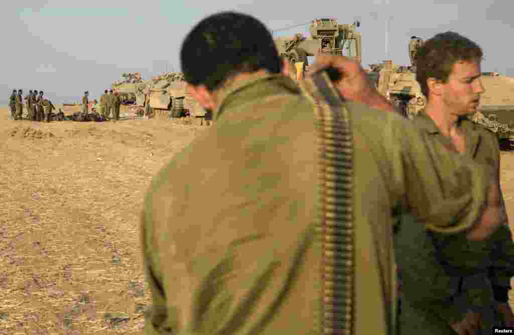Israeli soldiers gather at a staging area after crossing back into Israel from Gaza, July 28, 2014.