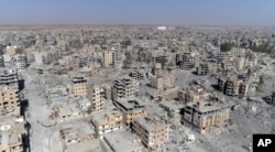 FILE - This Oct. 19, 2017 frame grab made from drone video shows damaged buildings in Raqqa, Syria.
