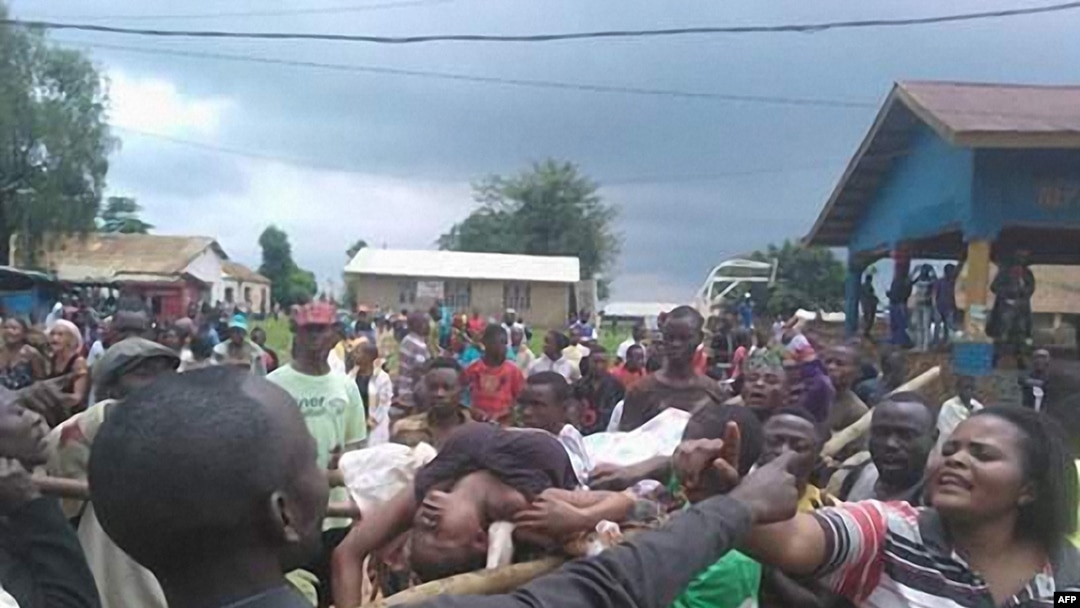 People argue as a woman is transported to the local hospital in Beni on August 15, 2016 during scenes of tension following a wave of unrest and violence in the region. At least 42 civilians have been killed in the eastern Democratic Republic of Congo, a local official said on August 14, in what the government described as a massacre in revenge for military operations in the area.
