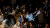 FILE - In this photo taken Feb. 18, 2018 photo, refugees and migrants sit on the deck of a rescue ship after being rescued by aid workers of the Spanish NGO Proactiva Open Arms. 