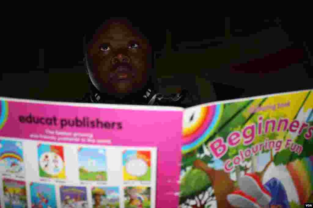 Sihle pages through a coloring-in book (VOA/ D. Taylor)