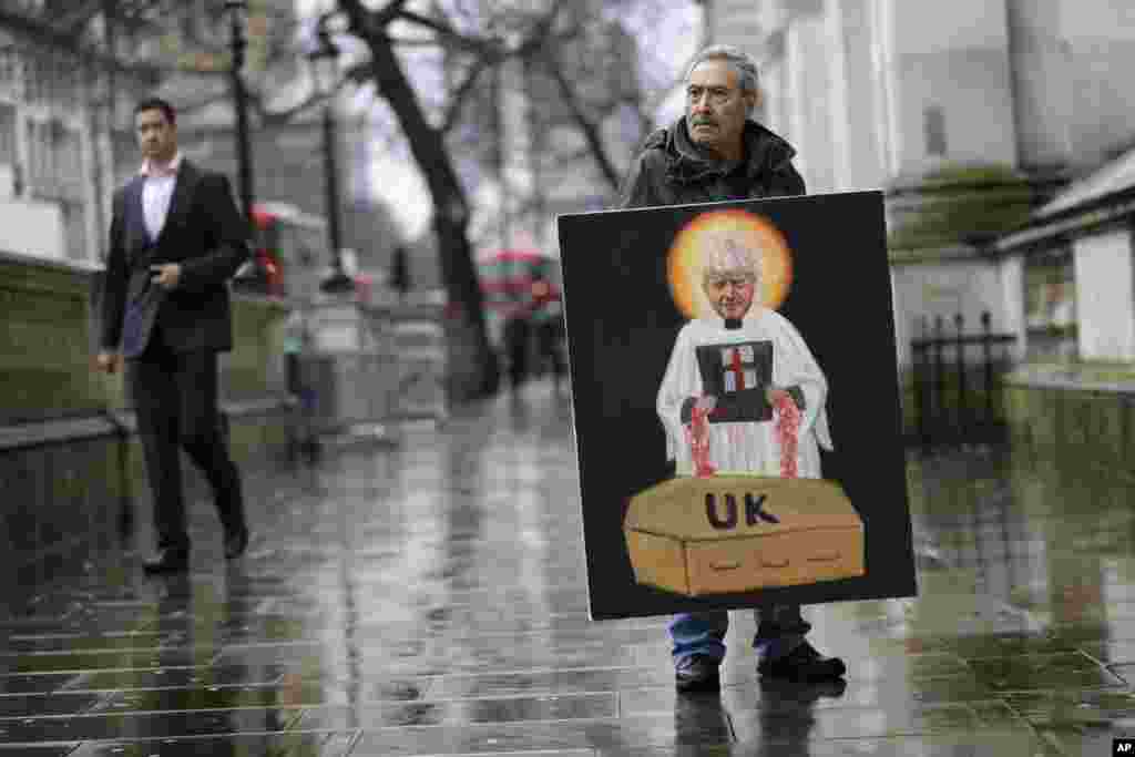 Artist Kaya Mar displays a painting of Britain's Prime Minister Boris Johnson in Westminster in London.