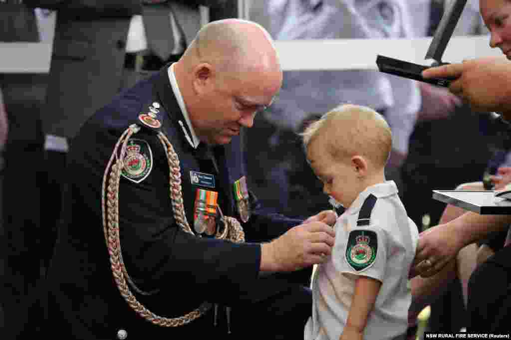RFS Commissioner Shane Fitzsimmons presents a posthumous Commendation for Bravery and Service to the son of volunteer firefighter Geoffrey Keaton at Keaton's funeral in Buxton, New South Wales, Australia, in this picture obtained from social media. Keaton was killed by wildfires in recent weeks.