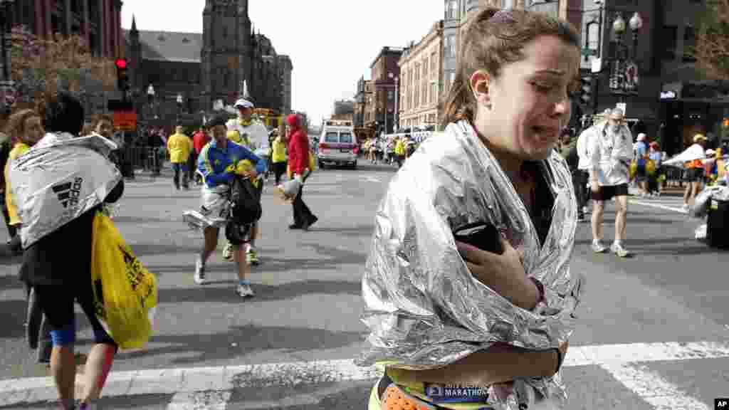 Uma corredora deixa a maratona de Boston a chorar na sequência da dupla explosão (15 Abril de 2013).