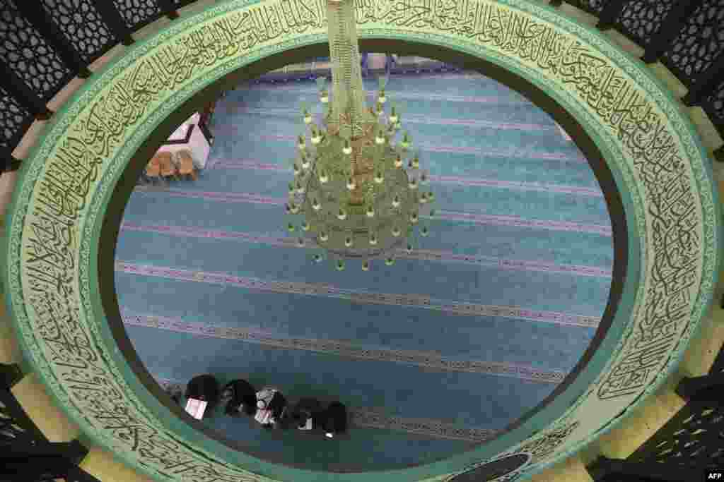 A few Palestinian worshippers pray at a mosque during the usually crowded weekly Friday prayers, in the midst of the coronavirus COVID-19 outbreak, in the West Bank town of Hebron.