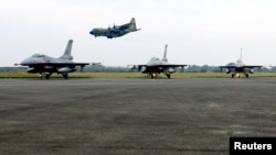 台灣空軍在嘉義舉行新年年度演習時一架C-130運輸機飛過兩架F-16V戰機的上空。 （2022年1月5日）
