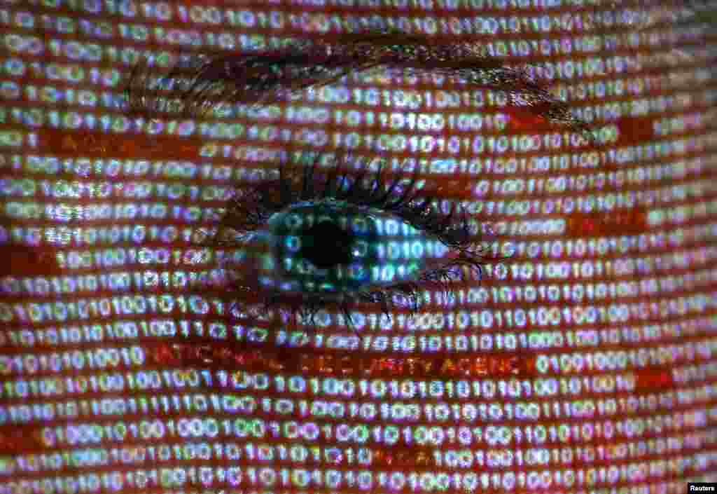 An illustration shows a projection of text on the face of a woman in Berlin, Germany. The European Union's chief justice official has written to the U.S. attorney general demanding an explanation for the collection of foreign nationals' data following disclosures about the "PRISM" spy program.