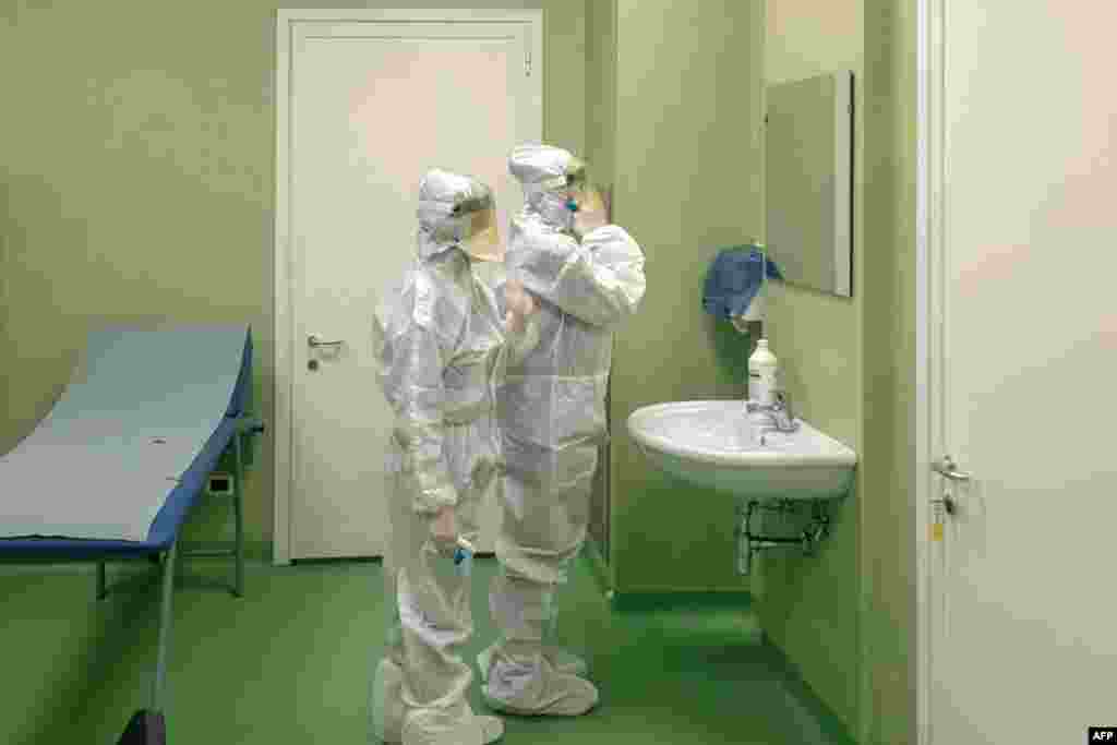 Members of a health team get ready to apply health measures and procedures against a new virus outbreak, after passengers landed at Rome's Fiumicino airport on a southern airlines flight from Wuhan, China.