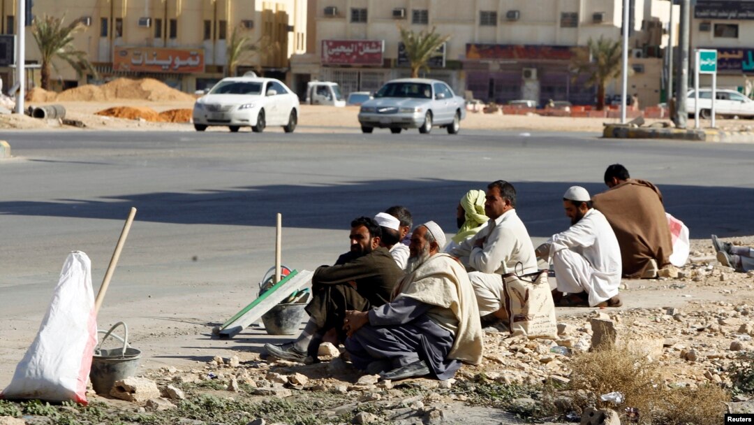 Foreign construction laborers rest on a street in Riyadh, Dec. 3, 2012.