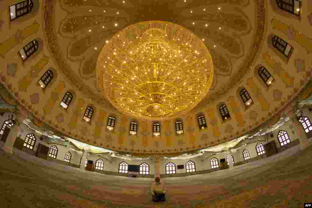 A man prays inside the closed Moussawi Grand Mosque in Basra, Iraq.