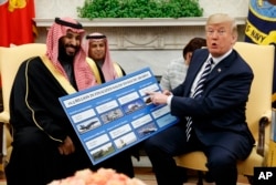 FILE - President Donald Trump shows a chart highlighting arms sales to Saudi Arabia during a meeting with Saudi Crown Prince Mohammed bin Salman in the Oval Office of the White House, March 20, 2018.