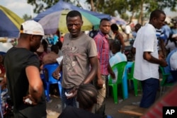 Supporters of Congolese President elect Felix Tshisekedi sell souvenirs outside his party headquarters in Kinshasa, Jan. 23, 2019. Tshisekedi is to be inaugurated Jan. 24, 2019.