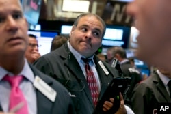 Trader Anthony Riccio works on the floor of the New York Stock Exchange Tuesday, Aug. 11, 2015. Prices for oil and copper fell sharply after China's government lowered the value of its currency.