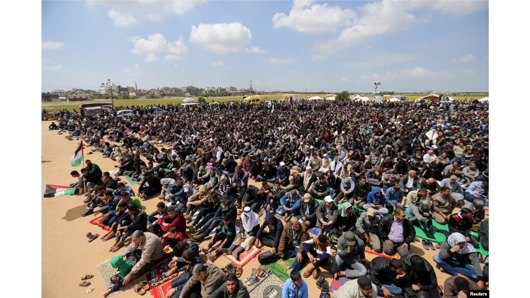 Palestinians attend Friday prayer during a tent city protest along the Israel border with Gaza, demanding the right to return to their homeland, in the southern Gaza Strip, March 30, 2018.