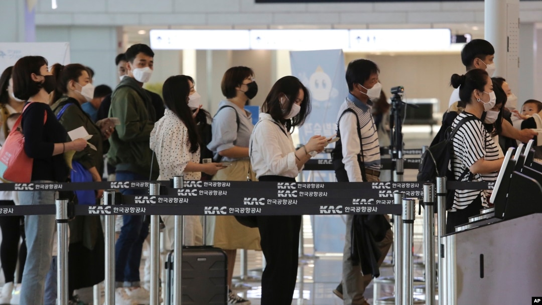 Putnici sa maskama stoje u redu, da bi se ukrcali na svoje letove, na terminalu za domaći saobraćaj na aerodromu Gimpo u Seulu, 27. maja 2020. (Foto: AP)