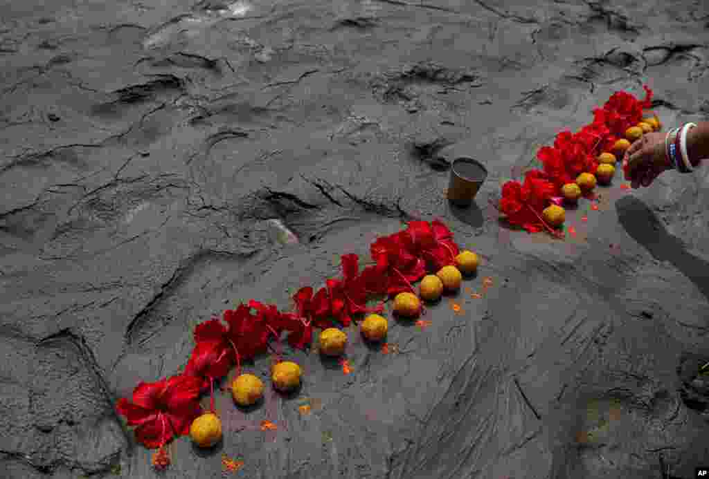 A Hindu woman performs rituals during a prayer ceremony to rid the world of coronavirus, on the banks of the river Brahmaputra in Gauhati, India.